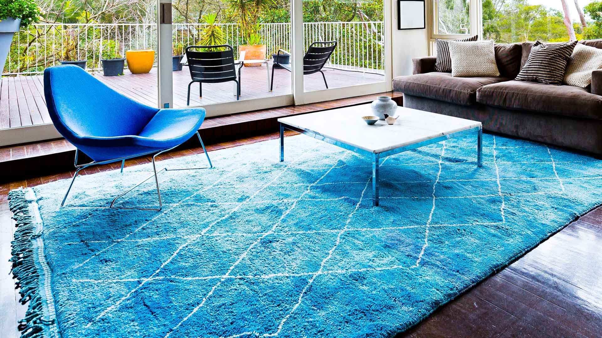 A bright blue wool rug in a sunny living room